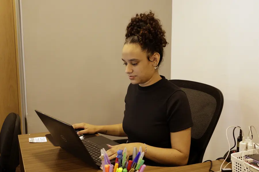 Atendente da GPM Assessoria trabalhando no notebook, no escritório