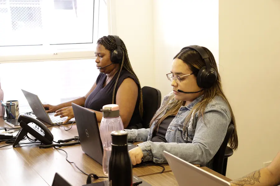 Atendentes da GPM com headset, em atendimento no escritório