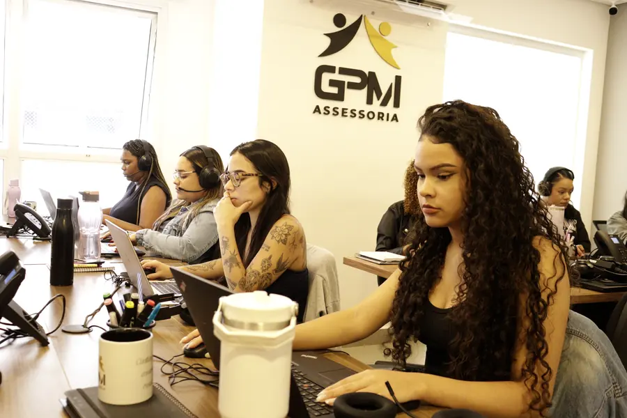 Atendentes da GPM lado a lado na mesa de trabalho